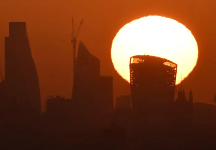 Framed Print : The sun is seen rising over skyscrapers in the City of London financial district in