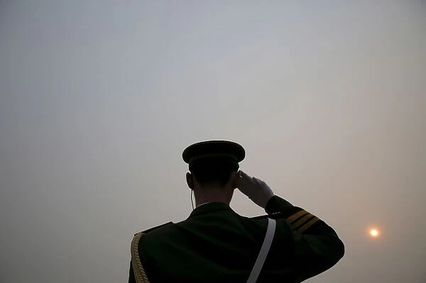 The sun is seen through smog on a severely polluted day as a paramilitary policeman