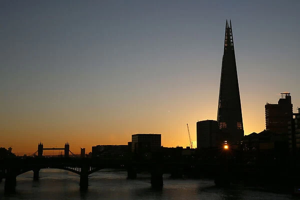 The sun is seen through a window of the Shard building during sunrise in central London
