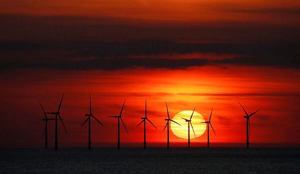 The sun sets behind the Burbo Bank wind farm near New Brighton