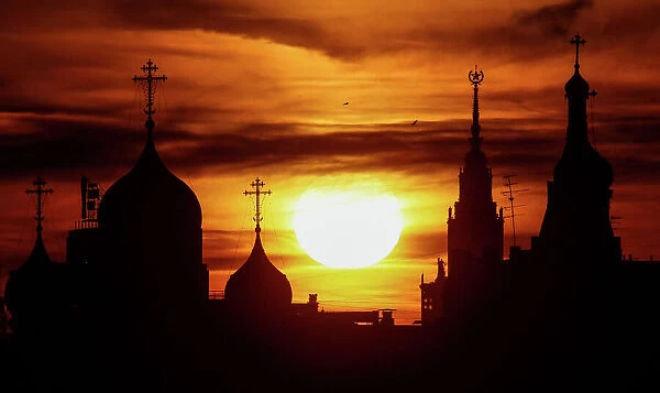 The sun sets over domes of the Andreevsky Monastery and the main building of the