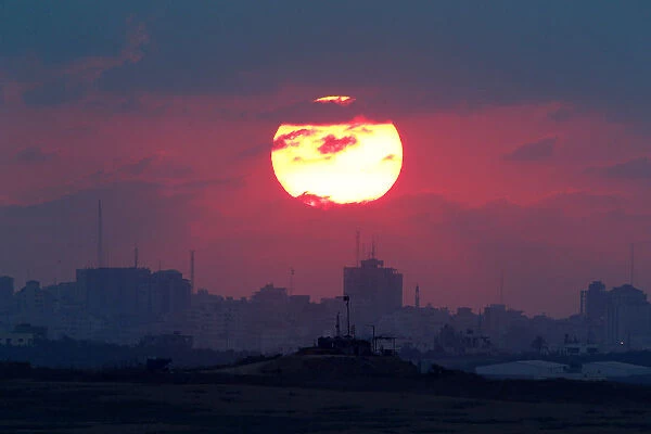 The sun sets over the Gaza Strip, as seen from the Israeli side