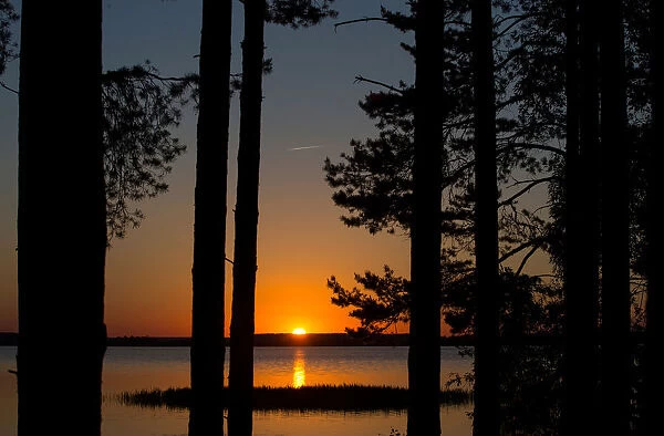 Sun sets behind a lake near the town of Vileika