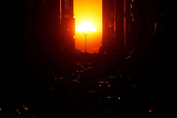The sun sets while lined up with 42nd Ave a few days after the Manhattanhenge phenomenon