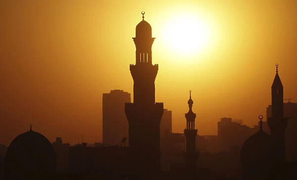 The sun sets over the minarets of mosques during the holy fasting month of Ramadan