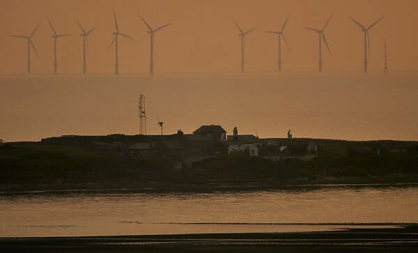 The sun sets behind the North Hoyle offshore wind farm