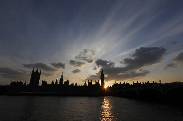 The sun sets behind the Palace of Westminster, in London