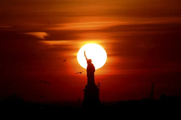 Framed Print : The sun sets behind the Statue of Liberty in New Yorks Harbor as seen from the Brooklyn Framed Print : The sun sets behind the Statue of Liberty in New Yorks Harbor as seen from the Brooklyn