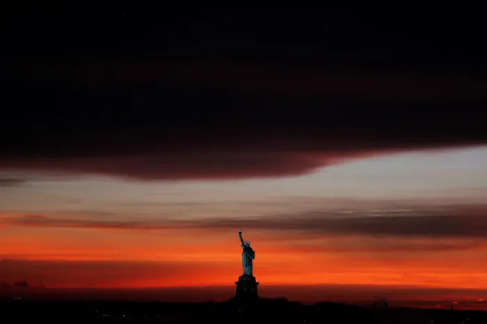 Framed Print : The sun sets behind the Statue of Liberty after a rain storm in New York Framed Print : The sun sets behind the Statue of Liberty after a rain storm in New York