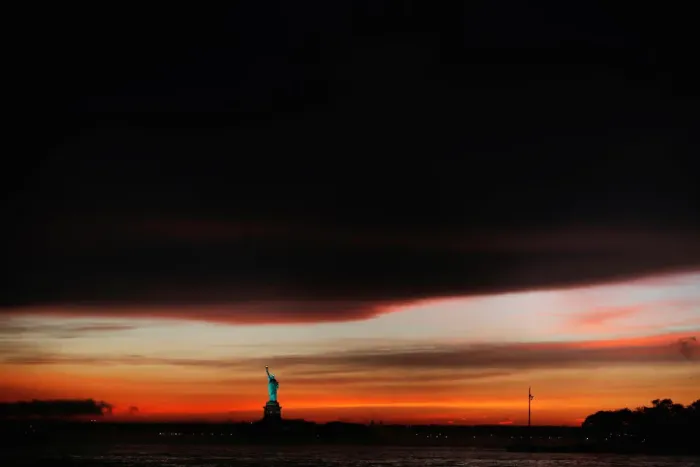 Framed Print : The sun sets behind the Statue of Liberty after a rain storm in New York Framed Print : The sun sets behind the Statue of Liberty after a rain storm in New York