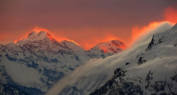 The sunset illuminates the peaks of the mountains near the Swiss mountain resort of St