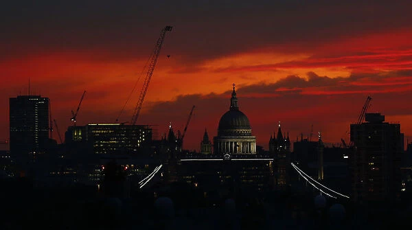 Sunset is seen behind St Pauls Cathedral in London
