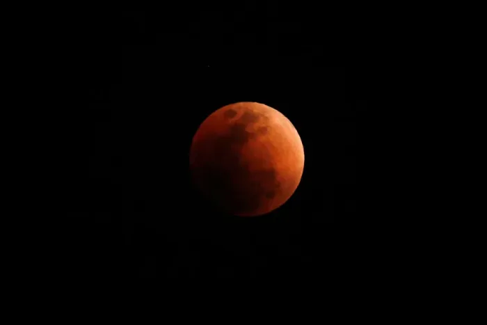Framed Print : A super blood blue moon is seen during an eclipse, behind an office building in Hong