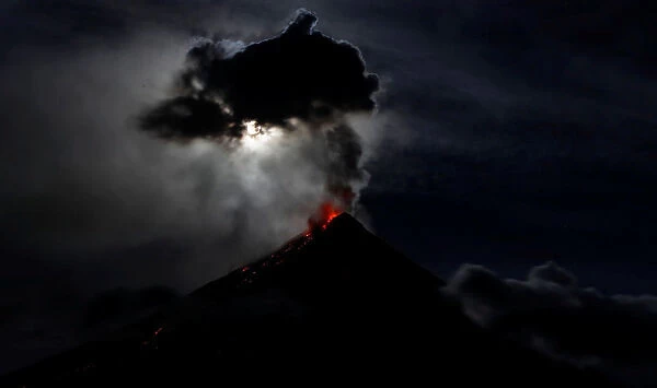 The super blue moon illuminates Mayon Volcano as it spews lava during a mild eruption