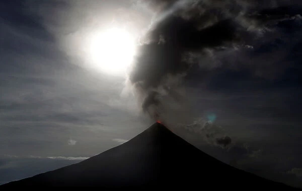 The super blue moon rises above the spewing Mayon Volcano during a mild eruption before a
