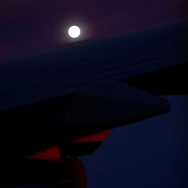 A supermoon full moon can be seen in the distance over the wing of Air Force One
