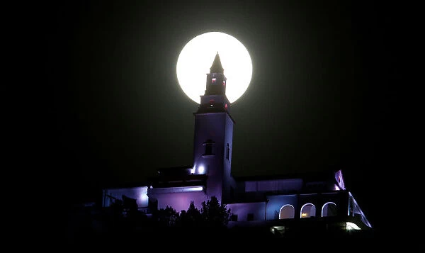 A supermoon is pictured next to the Monserrate church in Bogota