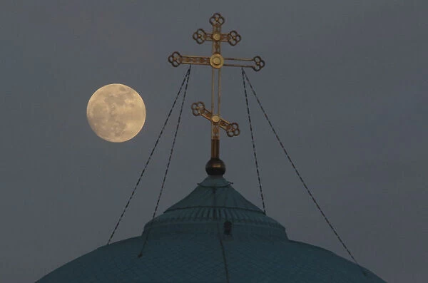 A supermoon rises behind the cross of the Saint Nicholas cathedral in Yevpatoriya