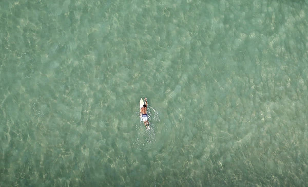 A surfer swims at Barra da Tijuca beach in Rio de Janeiro