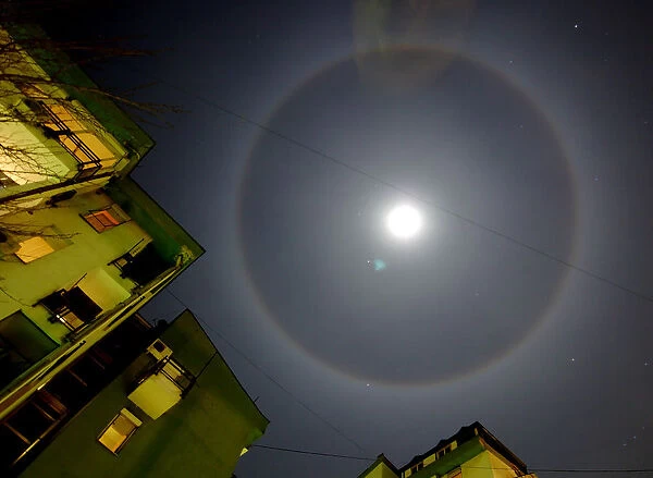 Surrounded by buildings, the moonlight forms a ring over Macedonias capital Skopje