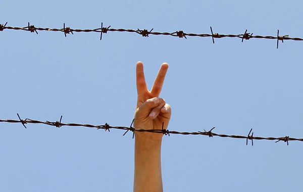 A Syrian flashes V-sign at a refugee camp in the Turkish border town of Altinozu in Hatay