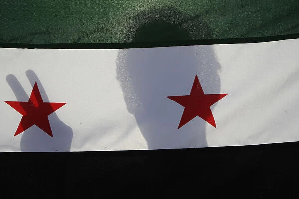 A Syrian protester holds a Syrian opposition flag during a demonstration
