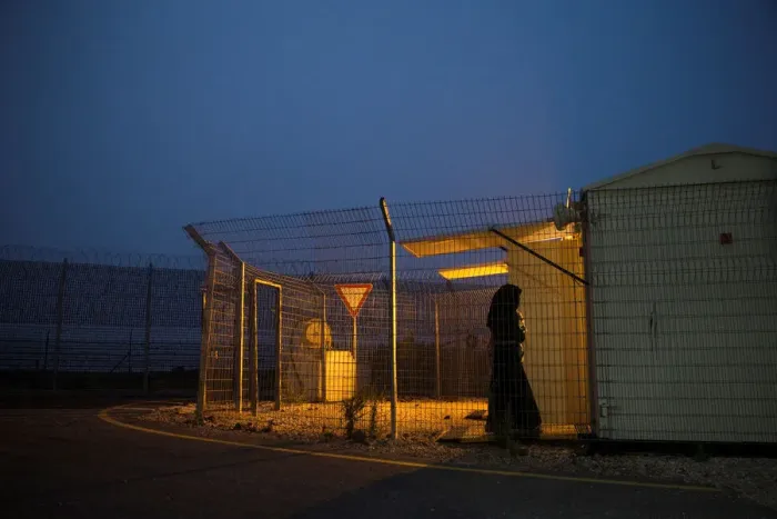 Framed Print : A Syrian woman holds a baby as she walks into a checking room just after they crossed