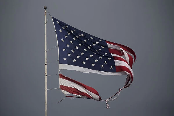 A tattered U. S. flag damaged in Hurricane Harvey, flies in Conroe, Texas