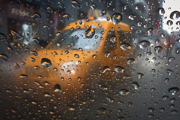 A taxi is pictured through the window of another taxi in the rain in Times Square