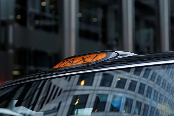 A taxi sign on top of an electric cab belonging to the London Electric Vehicle Company