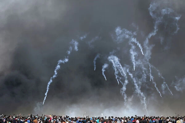 Tear gas canisters are fired by Israeli troops at Palestinian demonstrators during