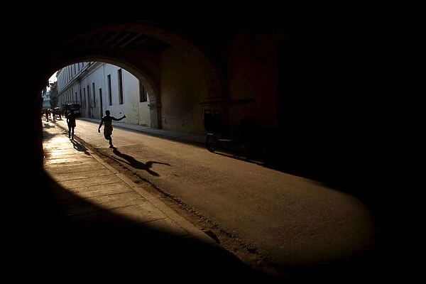 Teenagers play with a tennis ball in a tunnel in downtown Havana