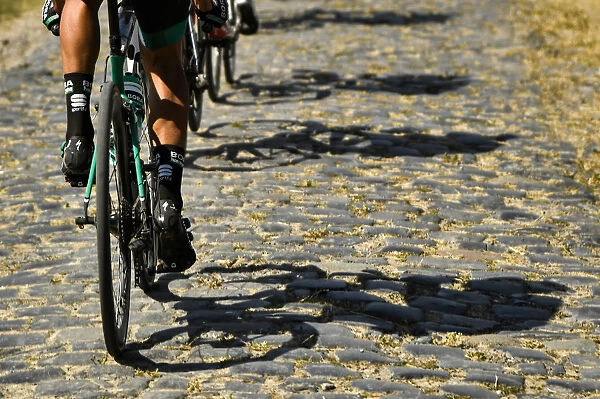 Tour de France - Riders shadows are cast on cobblestones