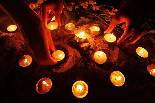 Tourists arrange oil lamps during candle light vigil ceremony on Thai island of Phi Phi