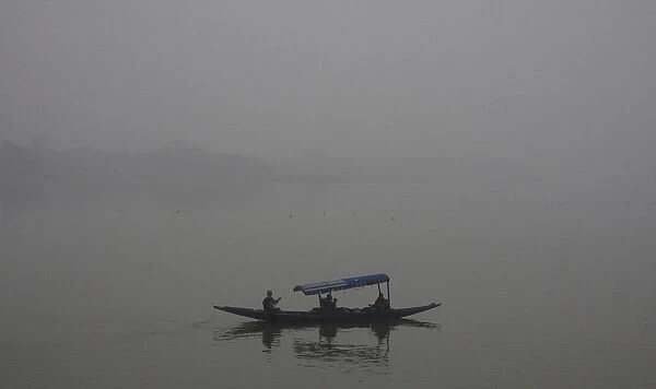 Tourists take a boat ride amid heavy fog at Sukhana Lake in Chandigarh