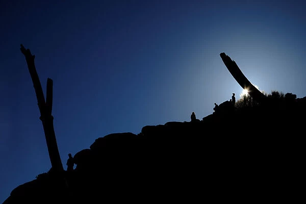 Tourists climb a hill at Guano Point on the west rim of the Grand Canyon on the Hualapai