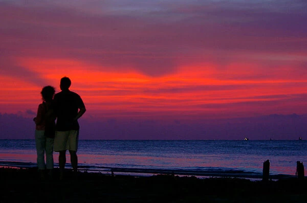 Tourists enjoy the sunset at Kovalam beach