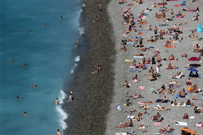 Framed Print : Tourists sunbathe and swim at the beach during a sunny summer day in Nice, southeastern