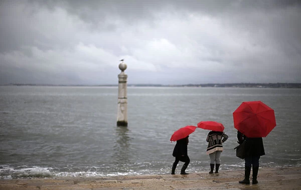 Tourists visit the Cais das Colunas in front of the Tagus River in Lisbon