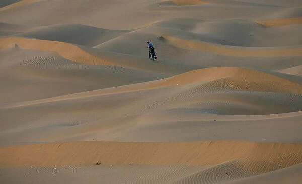 Tourists walk over the Thar Desert at Jaisalmer
