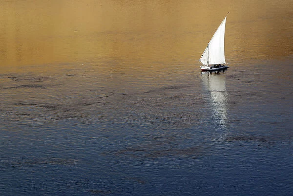 Traditional Egyptian Felucca boat sails on the Nile river in the southern Egyptian