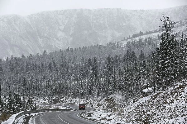 A truck drives along the M54 Yenisei highway during a snowfall in the Western Sayan