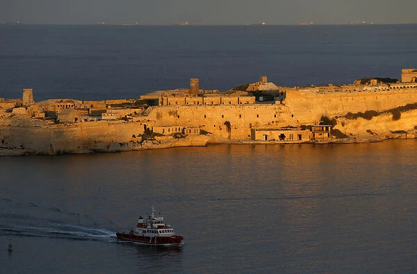 A tug boat passes the 17th century Fort Ricasoli as it enters Vallettas Grand Harbour