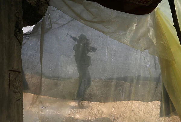 A Turkish-backed Free Syrian Army fighter carries his weapon as he walks on mount
