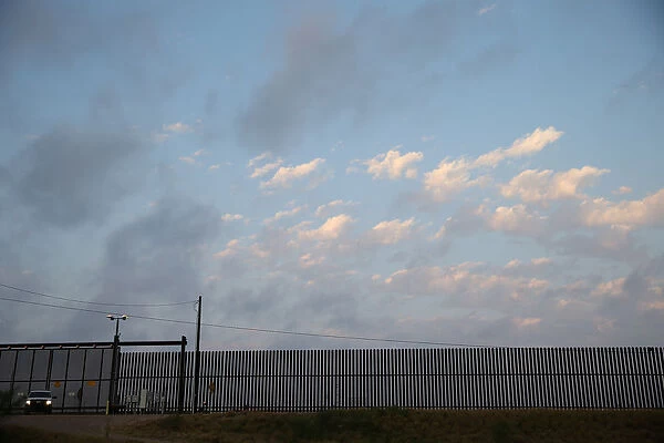 A U. S. Border Patrol agent guards a section of border fence by the Mexico-U. S