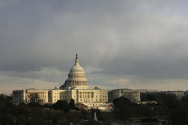 The U. S. Capitol building is seen as the sun begins to set under heavy cloud cover