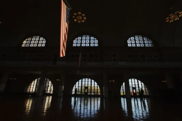 Framed Print : U. S. flag hangs in grand hall of the Ellis Island immigration museum building in New York Framed Print : U. S. flag hangs in grand hall of the Ellis Island immigration museum building in New York