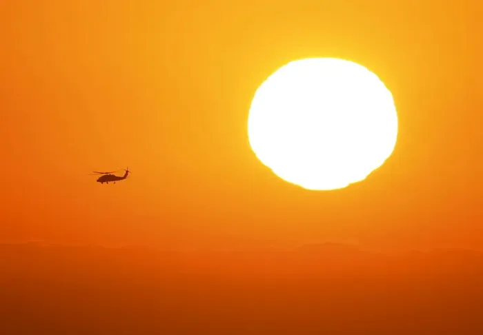 Framed Print : A U. S. military helicopter travels over the pacific ocean past a setting sun near Cardiff Framed Print : A U. S. military helicopter travels over the pacific ocean past a setting sun near Cardiff