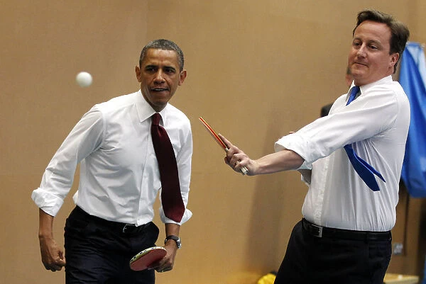 U. S. President Barack Obama plays table tennis against students with British Prime