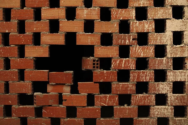 An unfinished brick wall is seen at a site where construction was halted after a lack
